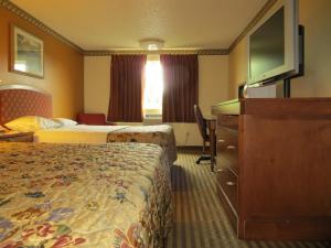a hotel room with two beds and a flat screen tv at Portland Inn in Portland