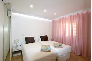 ヴィラモウラにあるVarandas do Sol 161 - Clever Detailsのベッドルーム1室(ベッド2台、ピンクのカーテン付)