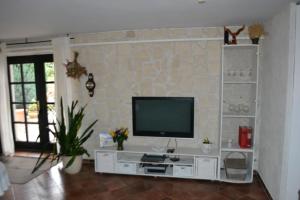 a living room with a tv on a stone wall at Apartment Edelweiß in Egsdorf