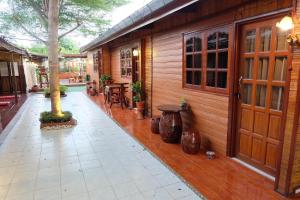 a porch of a wooden building with a table and chairs at Binlar Guesthouse in Phra Nakhon Si Ayutthaya
