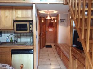 una pequeña cocina con una escalera que conduce a una habitación en HERMINE en Morillon