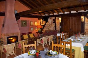 a restaurant with tables and chairs and a fireplace at La Tejera de Fausto in Requijada
