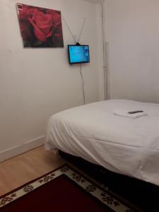 a bedroom with a bed and a tv on the wall at 20 East Tenter Street in London