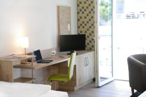 Televízia a/alebo spoločenská miestnosť v ubytovaní Adapt Apartments Giessen