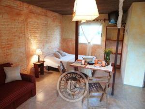 una sala de estar con una cama y una mesa en Complejo Los Girasoles, en Punta del Diablo