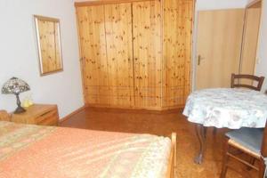 - une chambre avec un lit, une armoire et une table dans l'établissement Ferienwohnung im Grünen, à Berlin