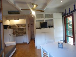 una cucina con armadi bianchi e un ventilatore a soffitto di Lo Chalet tra gli ulivi a Santa Margherita Ligure