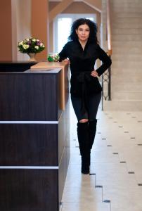 Una mujer con un vestido negro apoyada en un mostrador en Prestige Apartments Kalnyshevskogo, en Dnipro