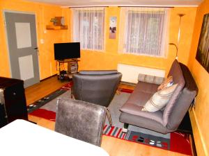 uma sala de estar com um sofá e uma cadeira em Haus Lindenblick em Lonsee
