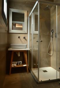 uma casa de banho com um chuveiro e um lavatório. em Hypnos Boutique Hotel em Nicósia