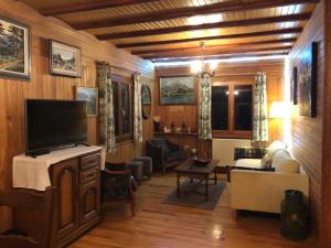 a living room with wooden walls and a flat screen tv at Chalet Braunkopf ALSACE in Muhlbach-sur-Munster