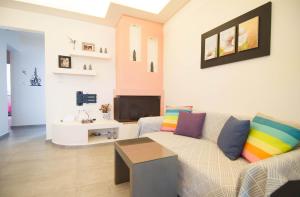 a living room with a couch with colorful pillows at Viglaki House in Naxos Chora