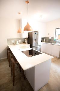 a white kitchen with a large white counter top at Maya Manor in Hoedspruit