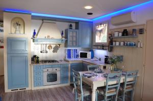 a kitchen with blue cabinets and a table with chairs at Una spettacolare vista mare - Casa con Jacuzzi in Bergeggi