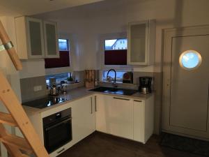 a kitchen with white cabinets and a sink at Ferienhaus: "Casa de Summer" in Birkenfelde