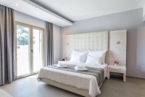 A bed or beds in a room at Aqua Oliva Resort Syvota