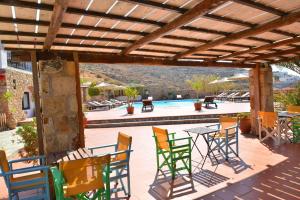 a patio with chairs and a table and a pool at Paradisia Villas in Naxos Chora