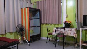 Camera con tavolo, sedie e ventilatore. di The Kong a Bangkok