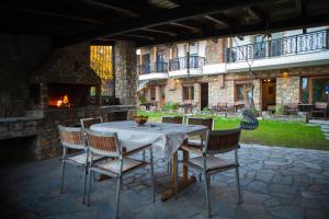 eine Terrasse mit einem Tisch, Stühlen und einem Kamin in der Unterkunft Spitiko in Kato Loutraki