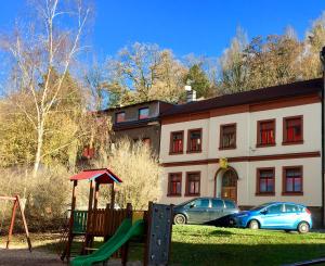 a playground in front of a building with parked cars at Cecilka in Náchod