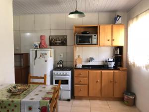 a kitchen with a stove and a refrigerator and a table at Cabanas Brocker in Gramado