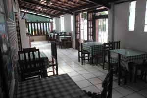 un restaurante vacío con mesas, sillas y ventanas en Pousada Vila Do Porto Ar Condicionado e Cafe Da Manha, en Porto Seguro