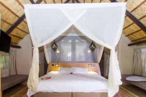 a bedroom with a bed with a mosquito net at The Royal Sichango Village in Livingstone