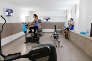 a woman exercising on a exercise bike in a gym at Hôtel In Situ in Béziers
