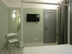 - une chambre avec un lit, un miroir et une télévision dans l'établissement Hotel 0482, à Odessa