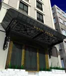 une entrée d'hôtel avec un panneau sur un bâtiment dans l'établissement Arber Hotel, à Tirana