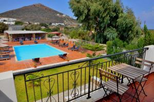 balcón con piscina, mesa y sillas en Country Villas en Stelida