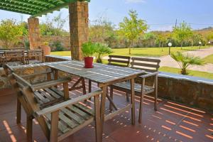 una mesa de madera y sillas en un patio en Country Villas en Stelida