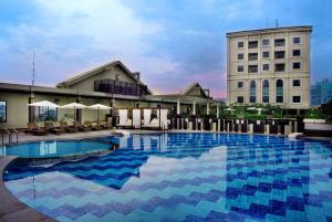 a large swimming pool in front of a building at Grand City Hall Hotel & Serviced Residences in Medan