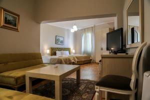 a living room with a couch and a table and a tv at Vila Arber in Golem