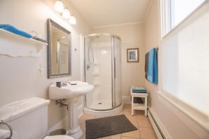 a white bathroom with a shower and a sink at River Ridge Lodge in Mahone Bay