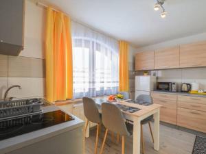 uma cozinha com uma mesa com cadeiras e um fogão em Apartamenty Lejówka em Chochołów