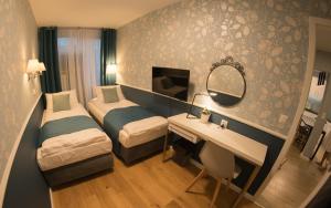 a hotel room with two beds and a desk and a mirror at Apartament Hotel Grzybowska 9 in Warsaw