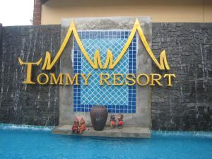 a sign for a luxury resort with figurines in front of a pool at Tommy Resort in Haad Rin