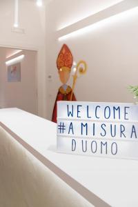 a welcome sign at the entrance to a museum in a building at A Misura Duomo Rooms & Apartment - LS Accommodations in Naples