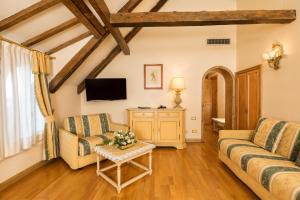 - un salon avec deux canapés et une télévision dans l'établissement Hotel Villa Laguna, sur le Lido de Venise
