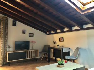 a living room with a television and a table and chairs at El Patrón in Chinchón