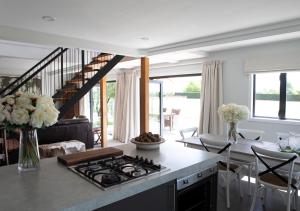 a kitchen with a stove and a living room at Black Walnut Cottage in Havelock North