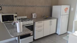 una pequeña cocina con fogones y nevera. en Casa More en Salta