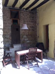 d'une terrasse avec une table en bois et 2 chaises. dans l'établissement Cal Cabrer - El Vilosell, à El Vilosell