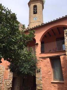 Cal Cabrer - El Vilosell في El Vilosell: مبنى عليه برج الساعه