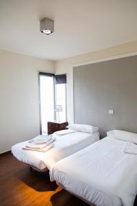 two beds in a room with a window at Casa 110 in Aldea del Fresno