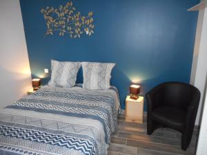 a bedroom with a bed and a black chair at GITE DE LA PECHERIE in Saint-Aignan