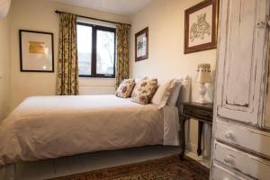 1 dormitorio con cama blanca y ventana en Dilkara Apartment Glastonbury en Glastonbury