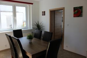 - une salle à manger avec une table et des chaises en bois dans l'établissement Apartment Dream, à Františkovy Lázně