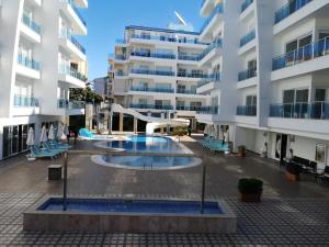 a large building with a swimming pool in front of it at Elite Life Residence 4 in Avsallar